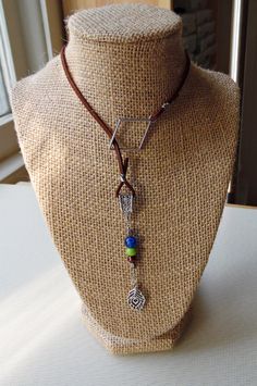 This brown faux suede lariat can be draped for a lower-sitting necklace--or double-wrapped for a shorter, choker-like look. Ornamented with a hand-beaded dangle made with Czech glass beads, as well as a silvertone peacock charm, this unique Peacock Feather Lariat completes any boho, southwest or casual look with simplicity and flair. Wire-wrapped by hand! You may also like our Peacock Beaded Necklace: https://www.etsy.com/listing/725488341/peacock-beaded-necklace-with-charm-and And our Peacock Feather Bracelet: https://www.etsy.com/listing/730270333/peacock-feather-bracelet-with-brown Peacock Feather Bracelet, Feather Bracelet, Tarot Bags, Feather Necklaces, Peacock Feather, Vintage Button, Lariat Necklace, Look Plus, Czech Glass Beads