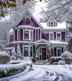 a large purple house with wreaths on the front and windows in snow covered yard