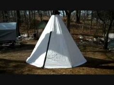 a large white tent sitting in the middle of a forest