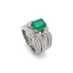 Gender: Ladies    Metal Type: 18K White Gold    Size: 5.5    Width: 2.85 mm    Ring measures approximately in width: 2.85 mm    Jacket measures in width: 8.50 mm    Weight: 15.69 grams    18K White Gold Diamond and Emerald Cocktail Ring with a soft-square shank. The ring is a size 5.5. The ring weighs a total of 15.69 grams. Engraved with "18K".    In Excellent Condition.    4-Prong Set in 18 Karat White Gold with:    One (1) natural, emerald-cut, step cut, emerald:    Species: Natural Beryl  Variety: Natural Emerald  Measurements: 8.66mm x 6.44mm x 3.83mm in depth.  Estimated Weight: 1.57 ct.  Cut Style: Crown Step Cut  Cut Style: Pavilion Step Cut  Color(s): Strongly Green  Clarity: Slightly Included (Type III)  Pavé set in 18 Karat White Gold with:    Fifty-four (54) round brilliant cut Formal Emerald Cut Gemstone Stackable Rings, White Gold Emerald Cut Stackable Rings, Stackable Emerald Cut White Gold Rings, Luxury Stackable Emerald Cut Emerald Ring, Luxury Stackable Emerald-cut Emerald Ring, Elegant Stackable Emerald Cut Rings, Formal Stackable Platinum Rings, Elegant Stackable Rings With Emerald Cut, Luxury Gemstone Stackable Rings For Formal Occasions