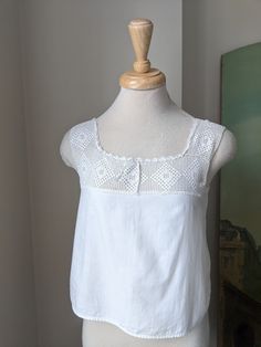 This Antique 1900s/10s white cotton + filet crochet camisole/corset cover would make a beautiful and breezy warm weather top! Drawstring at neckline, otherwise no closures.  Approximate Measurements of Garment laid flat: Bust: exactly 34"underarm to underarm, more like 34 1/2" below that  Waist: 36 1/2" Across bottom, it is 37" length: 17 1/2" from shoulder strap *Shown on 32"-25"-32" mannequin  XS Very good antique condition. Clean and intact overall, though there are a couple of hidden repairs Cotton Crochet Top With Lace Trim For Daywear, White Lace Top With Crochet Trim For Daywear, White Lace Top With Crochet Trim, Vintage Lace Trim Camisole Tank Top, Vintage Lace Trim Tank Top, Lace Top With Crochet Trim For Daywear, Cotton Crochet Top For Daywear, Sleeveless Cotton Lace Top With Crochet Trim, Vintage Cami Top For Daywear