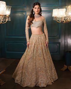 This lehenga set is hand embroidered in floral and geometric motis with a mix of light gold and sequin embroidered. Paired with a full sleeves embroidered wide-neck blouse and match dupatta.DELIVERY TIMEPlease allow 8-12 weeks for your outfit to arrive.FABRIC DETAILSNetProfessional cleaning only. Long Sleeve Choli With Dabka Work For Navratri, Long Sleeve Anarkali Set With Mirror Work For Reception, Long Sleeve Sharara With Dupatta For Reception, Elegant Long Sleeve Palazzo Set With Pallu, Festive Long Sleeve Anarkali Set With Mirror Work, Anarkali Sets With Long Sleeves For Reception, Long Sleeve Sharara For Diwali Reception, Bollywood Style Long Sleeve Palazzo Set For Reception, Long Sleeve Palazzo Set For Reception And Festivals