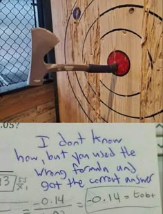 a dart hitting in the center of a wooden target with a note written on it