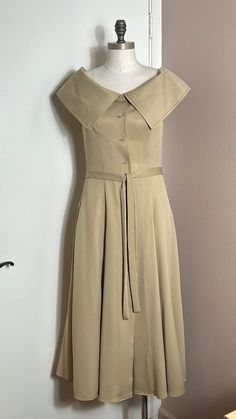 a dress on a mannequin next to a white wall