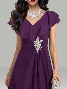 a woman wearing a purple dress with a flower on the waist and a diamond necklace