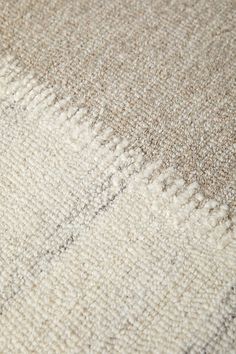 closeup of the texture of a rug with white and beige colors on it,