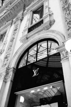 the entrance to an old fashion store in black and white