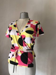 "90s Vintage does 70s stretchy double breasted top that features a very cool, geometric squared and circles pattern Shocking pink and bright yellow mixed with black and white makes it so groovy and some may say rave? It ties with a long cord all around the waist. It was then, in the early 90s that the super stylish dance band \"Deee Lite\" brought back that psychedelic style in fashion. (All the credits to the band!) ‼️Be aware - only one piece is available----- 🌀MEASUREMENTS: (taken while layi Colorful Retro Color Block Tops, Retro Multicolor Top With Vibrant Print, Retro Multicolor Top With Geometric Pattern, Retro Multicolor Abstract Print Tops, Retro Abstract Print Patterned Blouse, Cupro Fabric, Shocking Pink, Early 90s, Circle Pattern