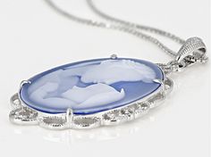 26x19mm Oval Carved Blue Agate "Mother And Child" Cameo Rhodium Over Silver Pendant With 18" box Chain. Measures approximately 1.62"L x .92"W. Lobster clasp. 2" extender. 2.5mm bail. Silver Cameo Necklace, Round Silver Cameo Necklace, Silver Cameo Oval Pendant Jewelry, Silver Oval Cameo Pendant Jewelry, Cameo Oval Pendant Jewelry For Anniversary, Anniversary Cameo Oval Pendant Jewelry, Silver Oval Intaglio Necklace, Silver Cameo Pendant Necklace, Silver Cameo Round Pendant Jewelry