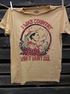 I Was Country When it wasn't Cool unisex distressed T shirt in vintage wash white and Mustard Vintage country western cowboy T shirt 40 Singles Jersey 100% Cotton Premium quality ringspun and compacted cotton Fine Cotton Jersey that is pigment dyed for a more vintage look Features tears and destroyed features at neck and on body Each piece is unique as this process is done by hand! 3.8 oz Made In USA Every garment dye item can be a slightly different shade in color since this is a laundry dye pr Distressed T Shirt, Cool Countries, Country Western, Vintage Country, Western Cowboy, Large White, Vintage Look, Vintage Tshirts, Vintage Looks