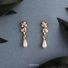 two pairs of gold and pearl earrings with leaves on the side, sitting next to each other