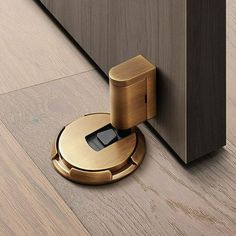 an electronic device is placed on the floor next to a door handle and wooden paneling