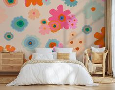 a bedroom with flowery wallpaper and white bed in front of the window, next to a wicker chair