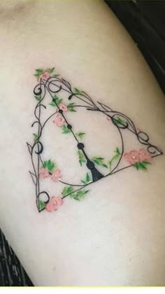 a tattoo design on the side of a woman's arm with flowers and a clock