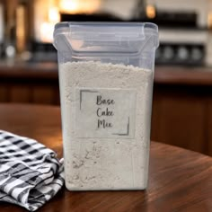 a plastic container filled with cake mix sitting on top of a wooden table