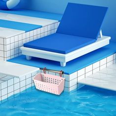 an empty swimming pool with blue and white tiles on the floor, next to a pink basket