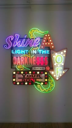 a neon sign that says shine a light in the darkness