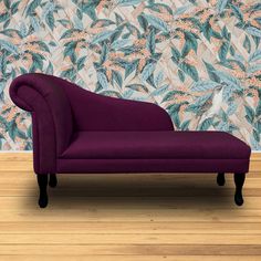 a purple chaise lounge sitting on top of a wooden floor next to a wall