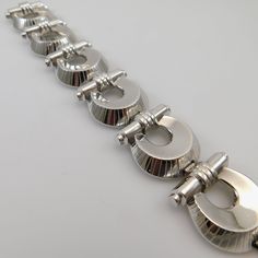 Vintage wide Etruscan revival bracelet is a substantial Monet bracelet, circa 1940. This silver tone statement bracelet has a push in box clasp with a MONET hang tag and safety chain. Clasp is also signed MONET. Bracelet measures 1 1/6 inch wide and 7 inches wide. Bracelet is in excellenting vintage condition - tongue to box clasp shows plating wear and the safety chain shows some discoloration. Any dark spots in pictures are glare - the silver tone metal is beautiful and shiny. Amazing statemen Antique Silver Hallmarked Metal Bracelets, Vintage Formal Chain Bracelet With Polished Finish, Vintage Silver Chain Bracelet With Polished Finish, Vintage Polished Chain Bracelet For Formal Occasions, Formal Vintage Sterling Silver Bracelet With Polished Finish, Sterling Silver Oyster Bracelet For Formal Occasions, Vintage White Gold Bracelet With Polished Finish, Sterling Silver Polished Finish Bracelet For Formal Events, Vintage White Gold Chain Bracelet For Formal Occasions