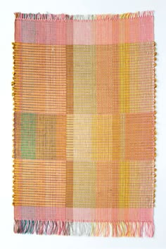 an orange, yellow and pink rug with fringes on the bottom half of it