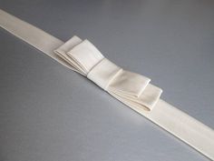 "This elegant simple bridal belt is beautifully made in silk Duchess satin. This belt features an elegant bow in the front and it is finished with the matching buttons and hand crochet loops in the back. This belt measures 1\" wide and the length is finished to your measurements. Available in a variety of colors. * Please include your waist measurements in the notes during checkout and your belt will be finished at that length - For the photos of the color choices please take a look at the listi Elegant Adjustable Sash For Formal Occasions, Elegant Adjustable Sashes For Formal Occasions, Adjustable Formal Sash Belt, Elegant Formal Adjustable Sash, Elegant Satin Bridal Accessories For Wedding, Elegant Formal Adjustable Sashes, Elegant Ribbon Bridal Belt For Wedding, Formal Adjustable Bridal Belt With Sashes, Elegant Bridal Accessories With Satin Bow