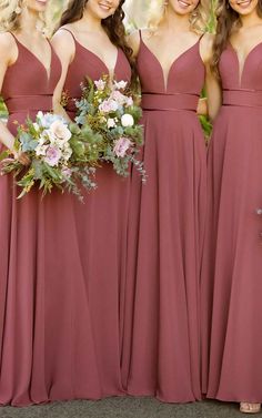 the bridesmaids are all wearing maroon dresses and holding bouquets in their hands