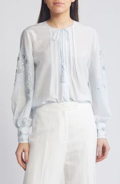 Swirling embroidery and sparkling sequins adorn the sleeves of this blousy silk-enriched top designed with a tassel-tie neck. 27" length Ties at neck Long sleeves 70% cotton, 30% silk Dry clean Imported Elegant Tops With Embroidered Cuffs, Elegant Fitted Tops With Embroidered Cuffs, Elegant Tops With Intricate Embroidery For Spring, Festive Long Sleeve Blouse With Embroidered Cuffs, Silk Long Sleeve Tops With Floral Embroidery, Spring Embellished Silk Tops, Elegant Festive Blouse With Blouson Sleeves, Elegant Blouson Sleeve Festive Blouse, Elegant Blouse With Blouson Sleeves For Festive Occasions