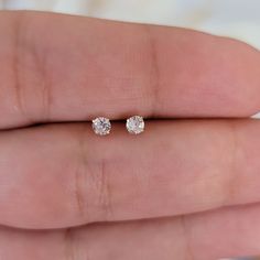 "Lovely two round brilliant cut diamonds, which are handset in 14k white gold basket mountings with push-backs. The diamonds are G-H in color and I1 in clarity. Earrings Available in natural diamond or clear cubic zirconia, please specify when placing your order. Height: 3mm Width: 3mm Thickness: 2.5mm Stone material: Center stone size: 3mm Stone shape: round Center stone carat weight:0.08 ct each Total number of CZ stones: 2 Total diamond weight: 0.16 Ctw Stone setting: prong setting Metal: Sol Minimalist White Gold Diamond Earrings With Vvs Clarity, Minimalist Vvs Clarity White Gold Diamond Earrings, Solitaire Round Earrings For Everyday, Minimalist Lab Grown Diamond Earrings With Accents, Everyday Diamond White Earrings With Diamond Cut, Minimalist Solitaire Round Earrings, Everyday Round Diamond Earrings, Minimalist Round Solitaire Earrings, Everyday Diamond White 14k Gold Earrings