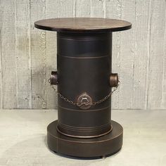 an old fashioned stove sitting on top of a wooden table with chains around it's legs