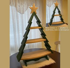 two wooden christmas trees sitting on top of a table