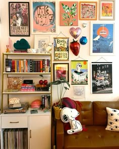 a living room filled with furniture and lots of pictures on the wall above it's bookshelf