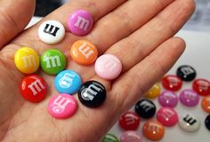 a person is holding some small magnets in their hand with the letters m and w on them