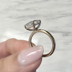 a person holding a ring with a diamond on it