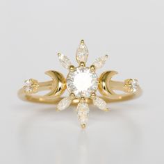 a yellow gold ring with a white diamond in the center and leaves on each side