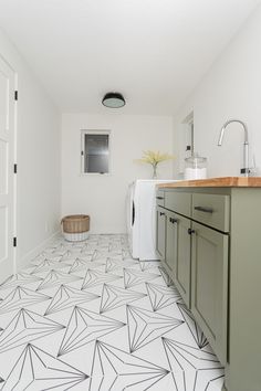 a white and black tiled floor in a kitchen next to a washer and dryer