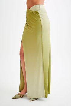 For a summer escapade.The BRONWYN Slinky Ruched Maxi Skirt With Split is a sophisticated and stylish piece designed to make a statement. Featuring a mid-rise fit and a flattering V front, this skirt enhances your natural curves. The centre front split adds a touch of allure, while the ruching at the side seams provides a chic, textured look. Made with stretch fabrication, it ensures comfort and ease of movement. For a complete and stunning outfit, pair this skirt with the Bronwyn Slinky Halter C Stretch Draped Evening Skirt, Stretch Ruched Bottoms For Evening, Evening Draped Stretch Skirt, Ruched Draped Maxi Skirt For Party, Draped Ruched Maxi Skirt For Party, Draped Bottoms For Summer Evening, Elegant Ruched Maxi Bottoms, Elegant Draped Skirt With Ruched Sides And Stretch, Draped Bottoms For Evening In Summer