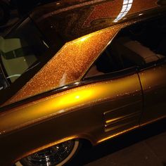 an old car with shiny gold paint on it