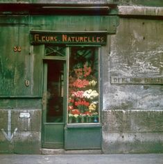 a store front with flowers on display in it's glass window and the words floriss naturelles written below