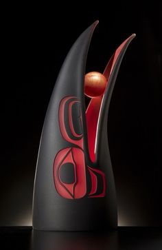 a black vase with red designs on it