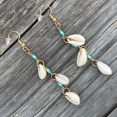 3 petite cowries on each earring connected by patterned Czech seed beads. 18k gold plated beading wire, 18k gold plated jump rings, and 18k gold plated ear wires. Summer Gold Jewelry With Dangling Beads, Bohemian Beaded 14k Gold Filled Earrings, Bohemian 14k Gold-filled Beaded Dangle Earrings, Bohemian 14k Gold Filled Beaded Dangle Earrings, Bohemian 14k Gold Filled Jewelry For Beach, Dangle Beaded Earrings With 14k Gold Filled, 14k Gold-filled Dangle Beaded Earrings With Gold Beads, 14k Gold-filled Beaded Dangle Earrings, 14k Gold Filled Dangle Beaded Earrings With Gold Beads