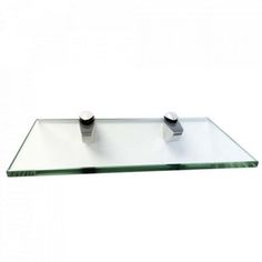 a glass shelf with two metal knobs on it