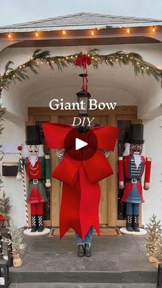 the giant bow is on display in front of a building with christmas decorations and lights