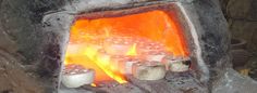 a fire burning in a stone oven filled with lots of marshmallows