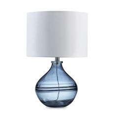 a blue glass table lamp with a white shade