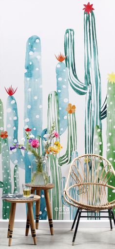 cactus wall mural in front of two chairs and table with vases on the side