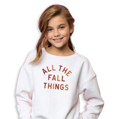 All The Fall Things graphic in cream or multi Fall colors on front of sweatshirt. Perfect for all your Fall activities (apple picking, pumpkin patches, Thanksgiving etc.) to show off your love for Fall/Autumn spirit! Personalization: 1. Type the color of graphic that you would like. Choice of Cream or Multi Fall Colors ONLY. Adult Sizes S-XXL (unisex sizing) Youth Sizes S-XL (unisex sizing) Sweatshirt colors vary. Toddler Sizes 2T, 3T, 4T (T-shirts Only) Baby Bodysuits 6 Months, 12 Months, 18 Months Gildan 18000 Heavy Blend, Port & Co, Jerzzees (availability varies) 50/50 cotton/polyester Classic, unisex fit 1x1 rib with spandex Bella + Canvas (Adult, Youth & Toddler Tees) 4.2 oz. Airlume combed and ring-spun cotton Pre-shrunk For a more relaxed fit, size up! Shipping || All orders over $3 White Cotton Sweater For Fall, Relaxed Fit T-shirt With Ribbed Cuffs For Fall, Relaxed Fit Sweater With Letter Print For Fall, White Tops With Text Print For Fall, White Tops For Fall, White Text Print Tops For Fall, Oversized White Sweatshirt For Fall, Trendy White Sweatshirt For Fall, White Cotton Fall Sweatshirt