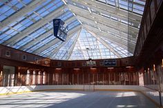 an indoor skating rink with glass ceiling and skylights