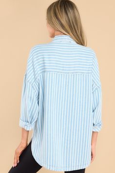 Looking for an effortless classic? This Always Lovely Blue Striped Top is your go-to for effortless, casual style. Throw it on and get ready for the compliments! This top features a collared neckline, functional buttons down the front, two functional bust pockets, long sleeves with buttoned cuffs, a scoop bottom hem, and a super soft material. Model is wearing a small. • 100% Lyocell • Hand Wash Cold • Unlined • Imported Trendy Blue Top With Collared Neckline, Light Wash Collared Tops For Day Out, Oversized Light Wash Button-up Top, Oversized Light Wash Top For Work, Blue Tops With Shirttail Hem For Spring, Blue Shirttail Hem Top For Spring, Trendy Light Wash Collared Top, Oversized Light Blue Collared Top, Oversized Collared Light Blue Top