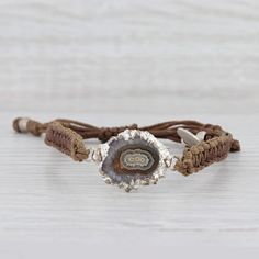 This lovely new bracelet is an authentic Nina Nguyen piece. This bracelet has a retail price of $195. Gem: Marbled Brown Geode Quartz Metal: Silver Toned Weight: 5.6 Grams  Stamps: Nina Nguyen Style: Brown woven chord with center charm Closure: Adjustable Drawstring Inner Circumference: 6"- 9 1/2" Width: 6.5 mm Charm: 16.7 x 26 mm Each piece is thoroughly examined and refinished as needed by our professional jewelers, graded by our in-house GIA (Gemological Institute of America) Graduate Gemolog Adjustable Artisan Sterling Silver Beaded Bracelets, Adjustable Artisan Hand Wrapped Bracelets, Unique Silver Adjustable Bracelet, Nickel-free Brown Bracelets As Gift, Nickel-free Brown Bracelets For Gifts, Adjustable Silver Bohemian Bracelet, Silver Adjustable Spiritual Bracelets, Adjustable Silver Spiritual Bracelets, Adjustable Nickel-free Spiritual Jewelry