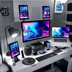 there are three computer screens on the desk